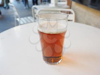Pint of British ale on a pub table - selective focus on beer over blurred background
