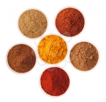 collection of indian spices (cumin, coriander, paprika, garam masala, curcuma, red pepper flakes) on glass cups isolated on white background