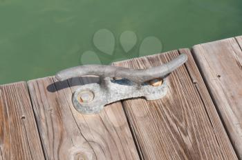 Royalty Free Photo of an Iron Mooring Cleat on a Wooden Pier