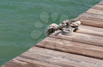 Royalty Free Photo of an Iron Mooring Cleat on a Wooden Pier