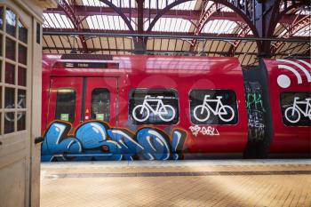 A train at a train-station with graffiti