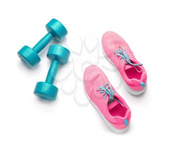 Dumbbells and sneakers on white background�