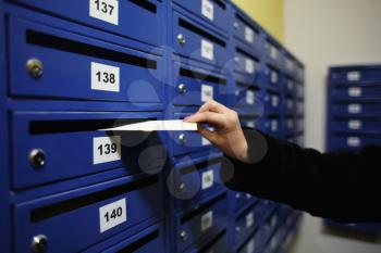 Woman putting letter into mailbox�