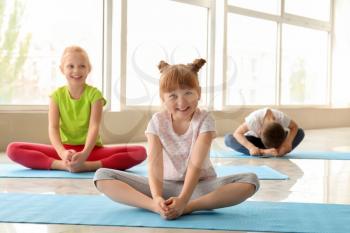 Little children practicing yoga indoors�