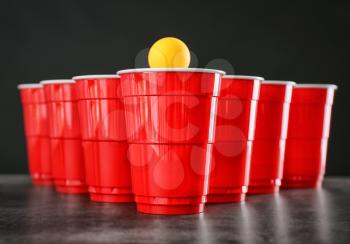 Cups and ball for beer pong on table�