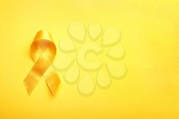 Yellow ribbon on color background. Cancer concept�
