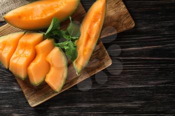 Ripe cut melon on wooden table�