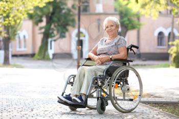 Senior woman in wheelchair outdoors�