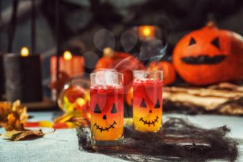 Creative glasses with jelly dessert prepared for Halloween party on table�