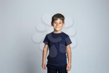 Cute little boy in t-shirt on grey background�