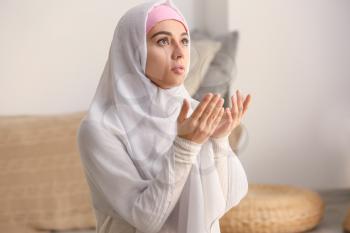Young Muslim woman praying at home�