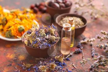 Aromatic dried flowers with essential oil on color table�