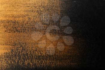 Strokes of gold paint on dark background�