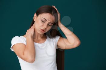 Woman suffering from headache on color background�