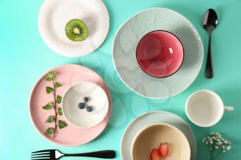 Tableware and cutlery on turquoise background�