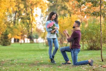 Young man proposing to his beloved in autumn park�