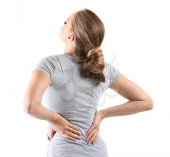 Young woman suffering from back pain on white background�