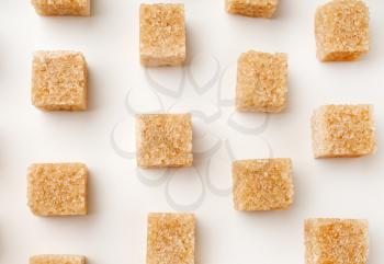 Brown cane sugar cubes on white background�