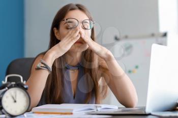 Tired businesswoman trying to meet deadline in office�
