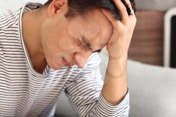 Young man suffering from headache at home�