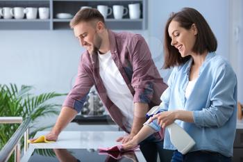 Young couple cleaning kitchen together�