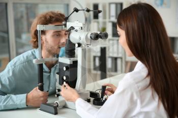 Ophthalmologist examining young man in clinic�