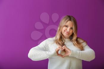 Beautiful plus size girl making heart with hands on color background. Concept of body positivity�