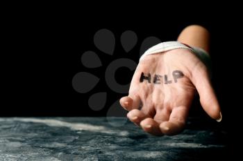 Woman with wrist bandage and word help written on her palm. Suicide awareness concept�