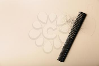 Comb with fallen down hair on color background�