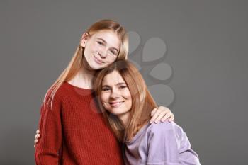 Portrait of happy mother and daughter on grey background�