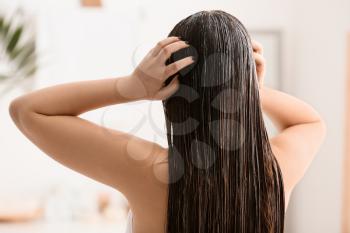 Young woman with beautiful long hair in bathroom�