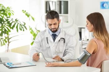 Male doctor working with female patient in clinic�