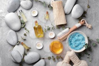 Spa composition with stones and cosmetics on grey background�