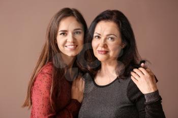 Portrait of young woman with her mother on color background�