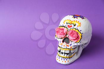 Painted human skull for Mexico's Day of the Dead on color background�