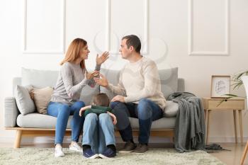 Sad little boy with his quarreling parents at home�