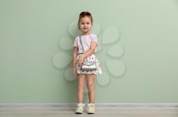 Portrait of cute little girl near color wall�
