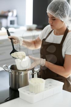 Woman preparing tasty cheese in kitchen�