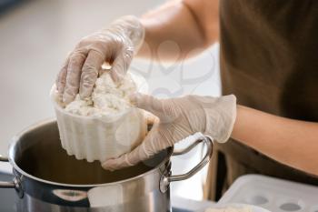 Woman preparing tasty cheese in kitchen, closeup�