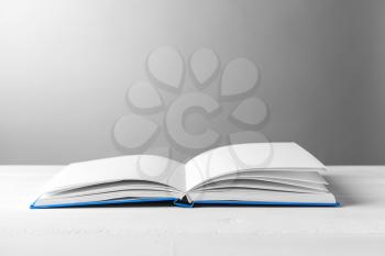 Open book on table against grey background�