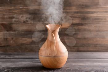 Aroma oil diffuser on wooden background�