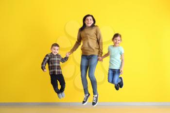 Happy jumping family on color background�
