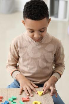 Little boy composing words of letters at speech therapist office�