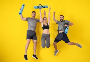 Young sporty people jumping against color background�