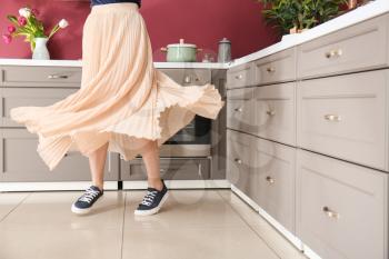 Young woman dancing in modern kitchen�