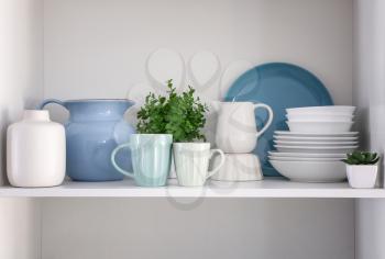 Shelf with clean dishes in kitchen�