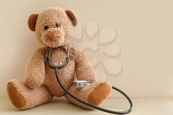 Toy bear with stethoscope on table�