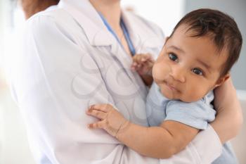 Pediatrician with African-American baby in clinic�