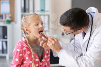 Pediatrician examining little girl in clinic�