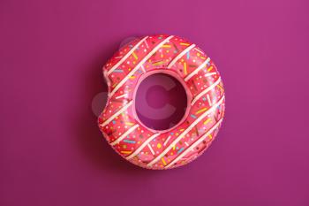 Bright inflatable ring on color background�
